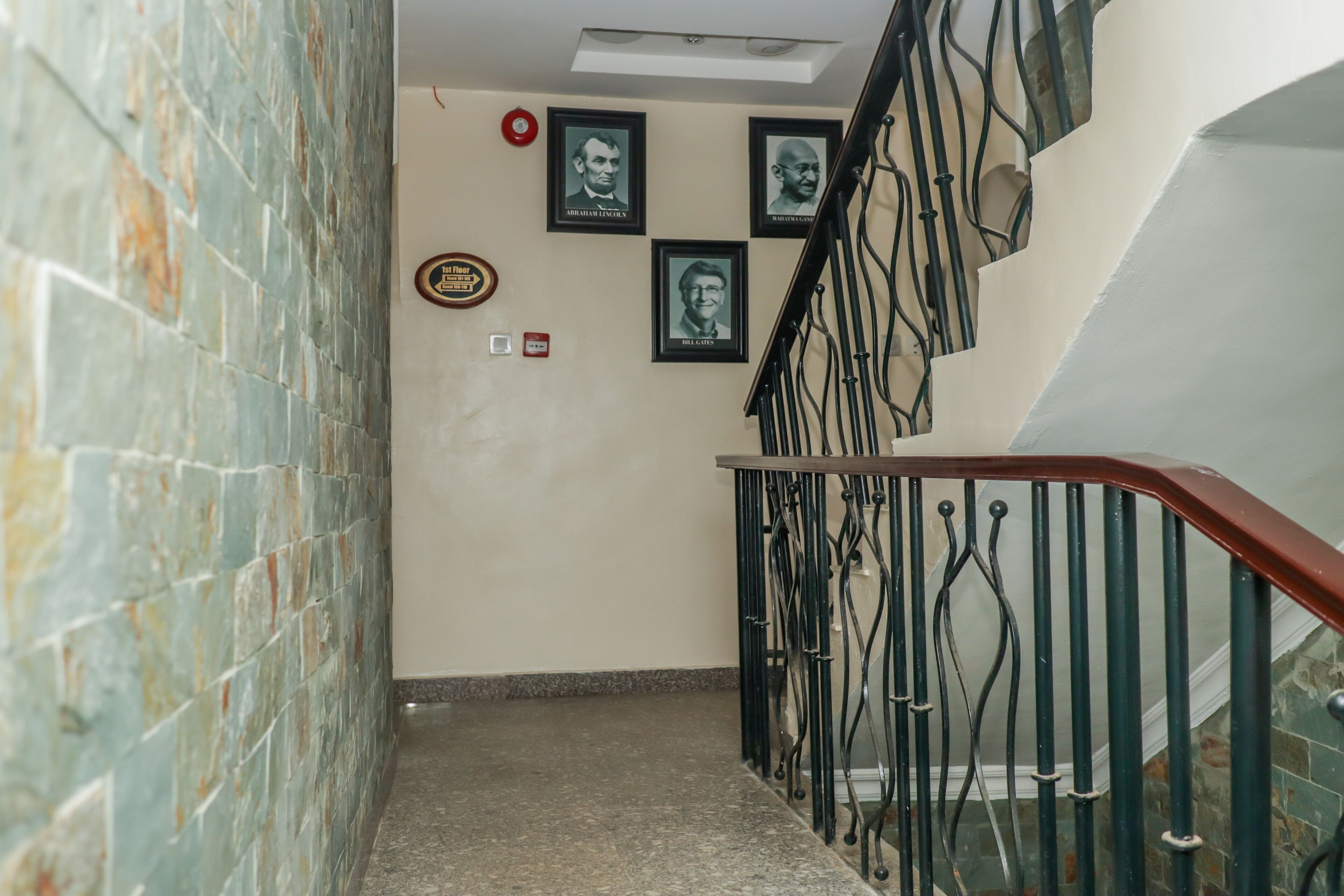 A staircase with a stone wall on one side and a metal railing on the other.