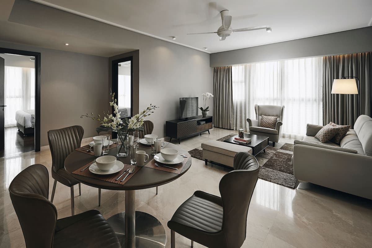 A modern living room with a dining area, a sofa, a TV, and a ceiling fan.