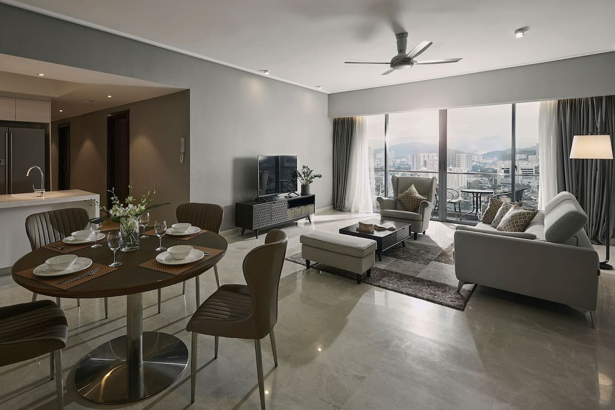 A modern living room with a dining area, a sofa, a TV, and a city view.