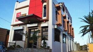A modern building with a prominent red section and a sign that reads "Casa de". - Casa Del Camba Hotel and Restaurant near Hundred Islands (Alaminos)