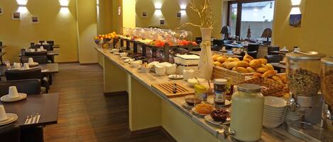 Montaje tipo buffet con diferentes opciones de comida y una estación de café.