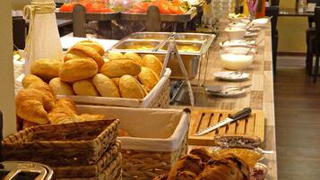 Un bufé con panes y pastelería variados.