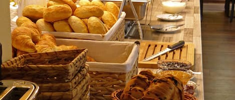 Un bufé con panes y pastelería variados.