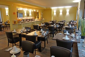 A restaurant with multiple tables and chairs, a buffet counter with food and drinks, and a mirror above the counter. - Neptuns Ankerplatz & Zur Seerobbe (Cuxhaven)