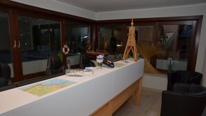 Un lungo tavolo con una mappa, un modellino di nave e una torre in legno.