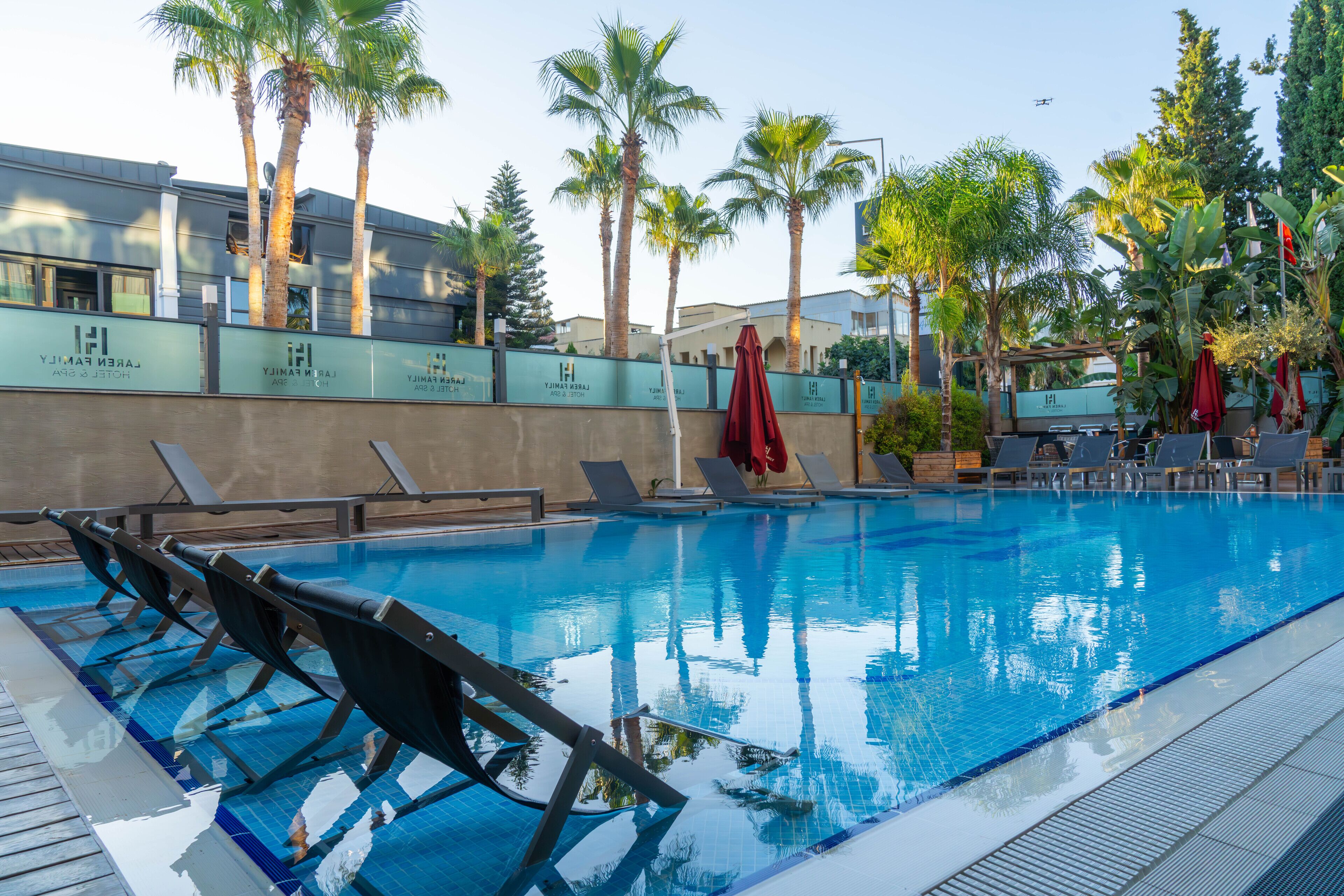 Una piscina al aire libre, sombrillas, tumbonas