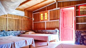 A room with two beds, wooden walls, and a red door. - Sahara Beach Camp (Nuweiba)