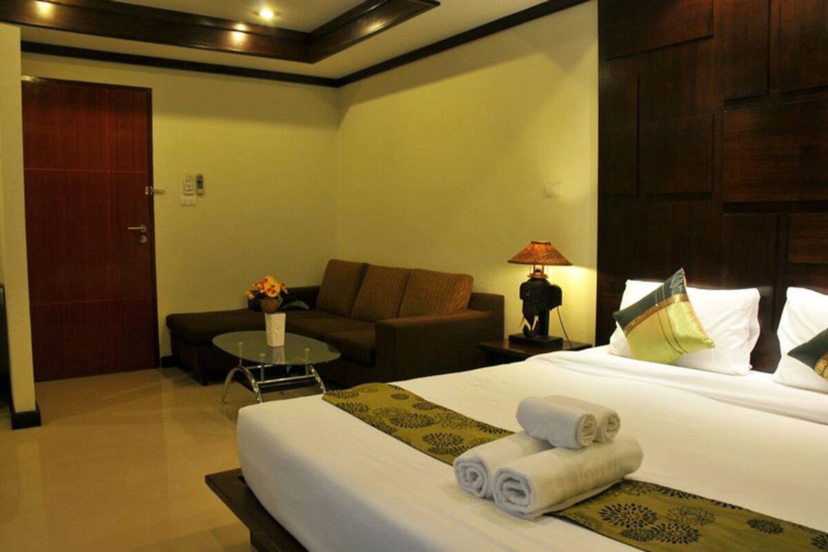Ein Hotelzimmer mit einem Bett, einem Schlafsofa, einem kleinen Tisch und einer Lampe.