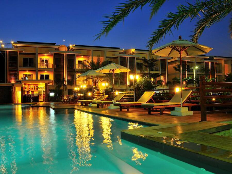 Een buitenzwembad, ligstoelen bij het zwembad