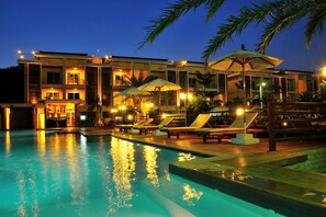 A modern hotel with a swimming pool, sun loungers, and umbrellas. - Boonjumnong Modern Apartment (Koh Samui)