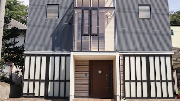 Un bâtiment moderne à deux étages, doté d’une façade symétrique, de grandes fenêtres et d’une entrée centrale avec une porte.