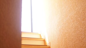 Un escalier montant, avec une source de lumière vive au sommet.