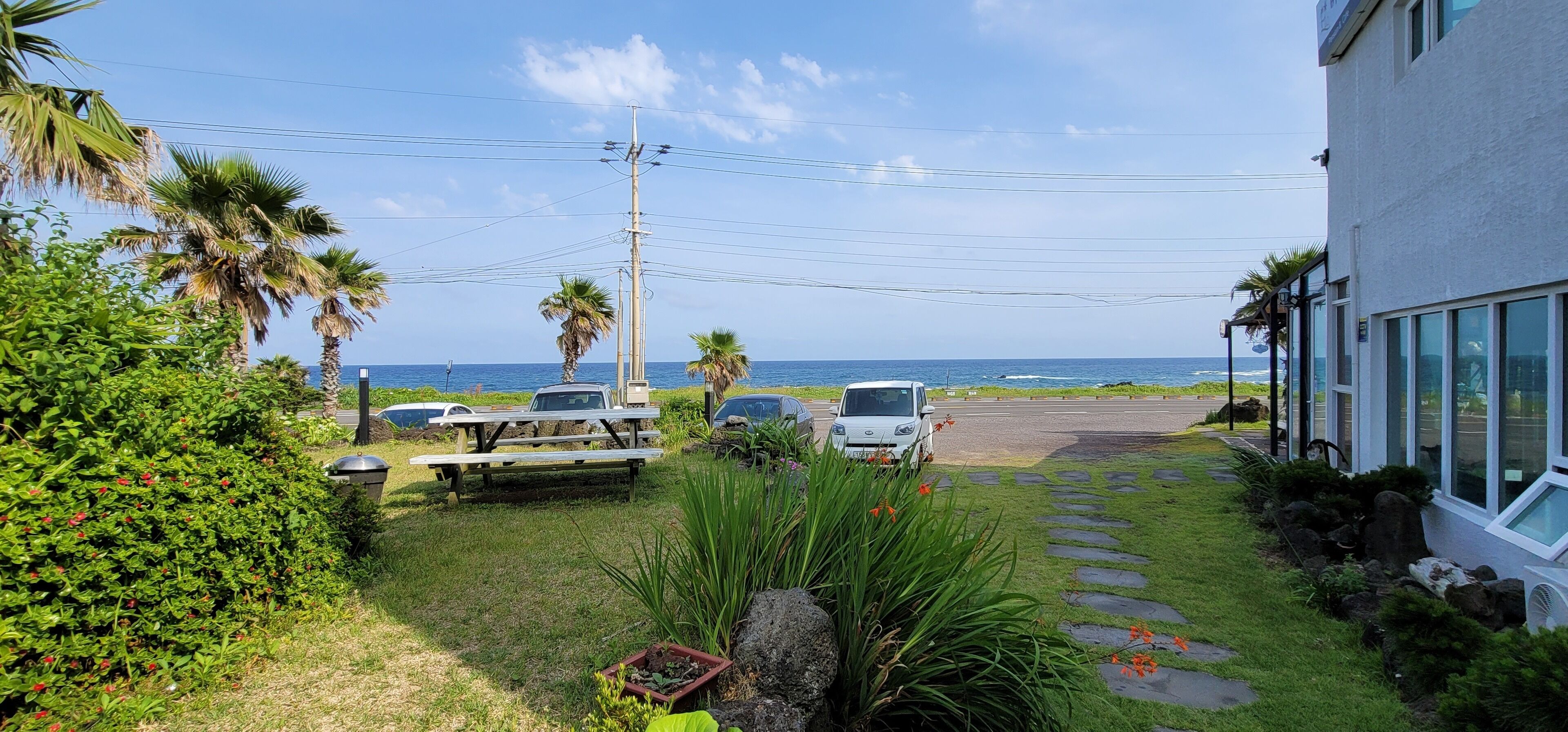 A parking area with a picnic table and a white car.