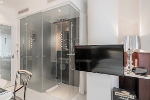 Eenvoudige eenpersoonskamer | Badkamer | Een douche, een regendouche, designer toiletartikelen, een haardroger