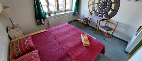Un dormitorio con cama, escritorio y silla.