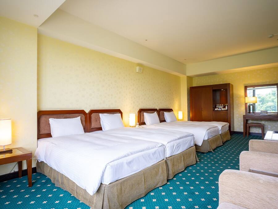 Een hotelkamer met twee bedden, een bureau, een stoel en een spiegel.