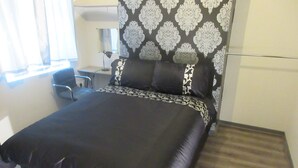 A hotel room with a bed, a desk, and a chair. - Magdala House (Liverpool)