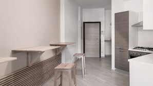 A modern kitchen with a built-in stove, wooden flooring, and a minimalist design. - B&B Jonio Roma (Rome)