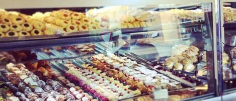 Vitrina de panadería con diversos pasteles y postres.