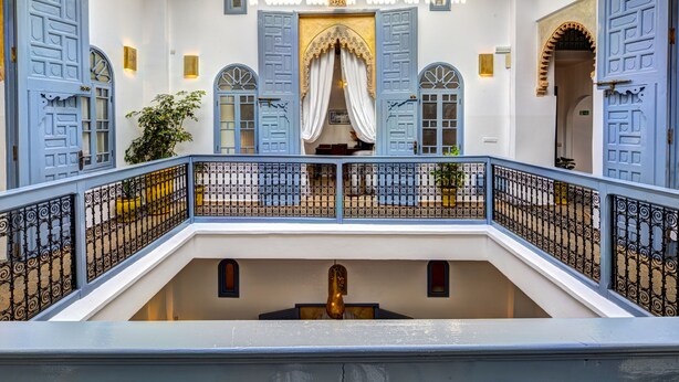 A multi-level building with blue doors and a central balcony with a railing. - Riad Amaris (Rabat)