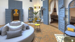 A cozy interior with a round seating area, a potted plant, and a patterned rug. - Riad Amaris (Rabat)