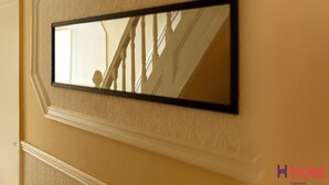 A mirror on a wall with a reflection of a staircase.