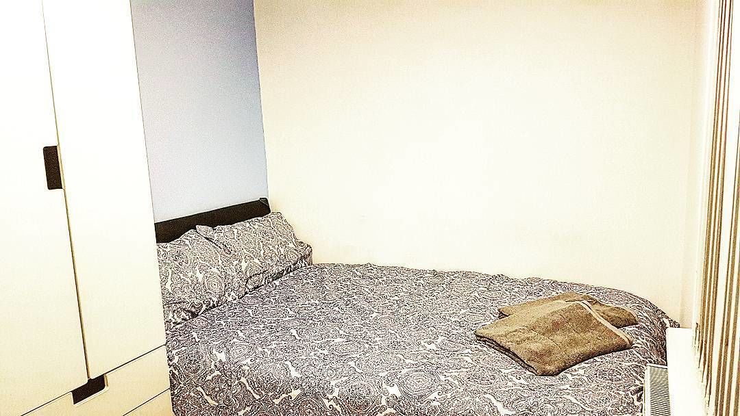 A bedroom with a bed, a pillow, and a wardrobe.