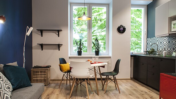 Une cuisine moderne avec un coin repas, un plancher en bois et une vue par la fenêtre.