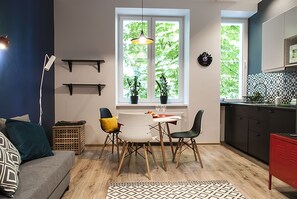 Una cocina moderna con comedor, suelo de madera y vistas al exterior.