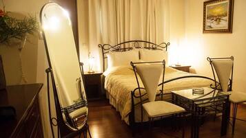 Ein Hotelzimmer mit Bett, Stuhl, Tisch und Spiegel.