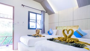 Habitación de hotel con dos camas, una ventana y vistas a zonas verdes.
