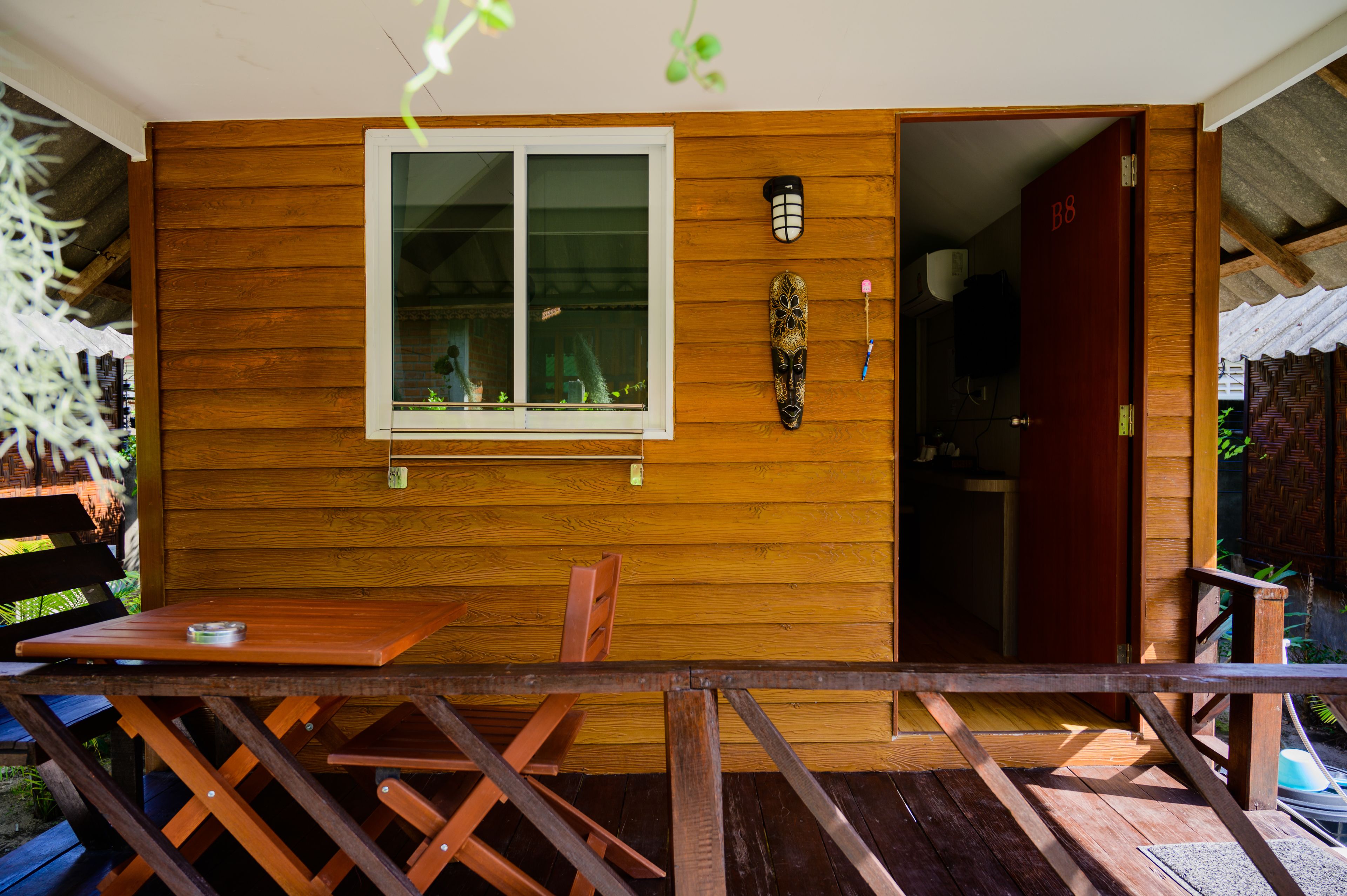 Una cabaña de madera con comedor, una ventana y una puerta identificada con 