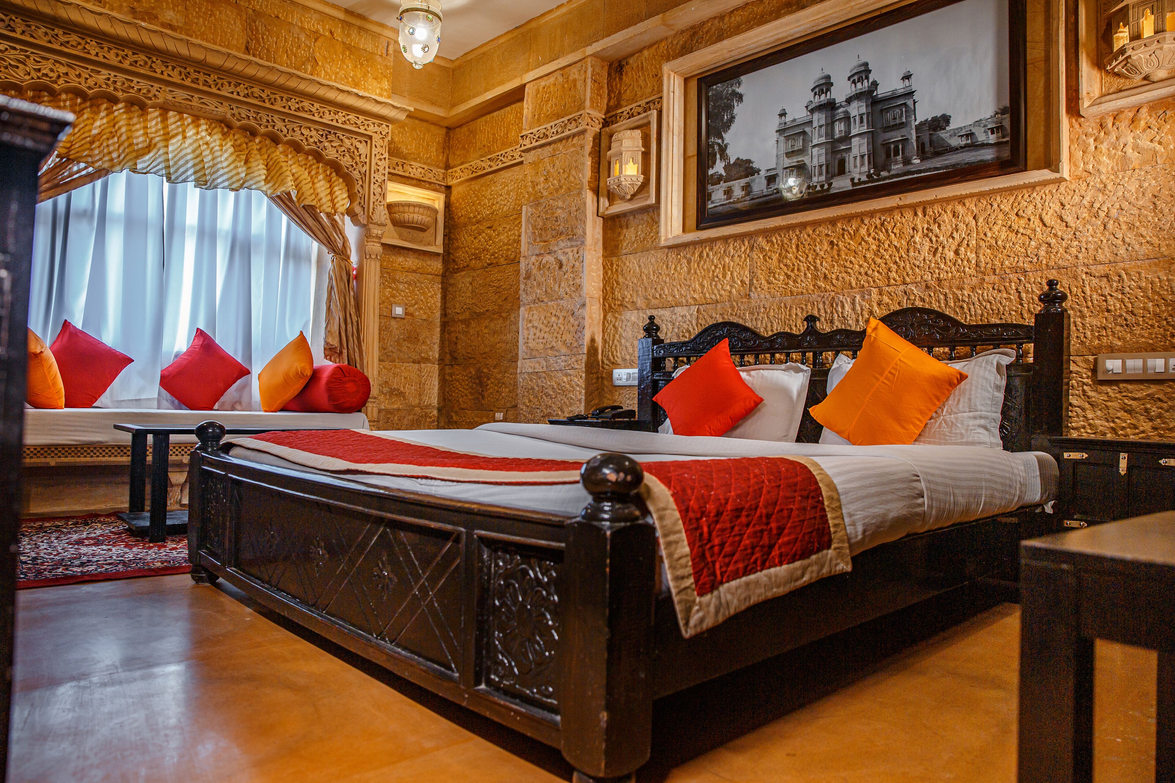 Une chambre de style traditionnel, dotée d’un grand lit, d’une tête de lit en bois sculptée et d’un tableau encadré accroché au mur.