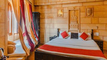 A room with a bed, a nightstand, a wardrobe, and a wall-mounted light fixture.