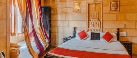 Une chambre comprenant un lit, une table de chevet, une armoire et un luminaire fixé au mur.