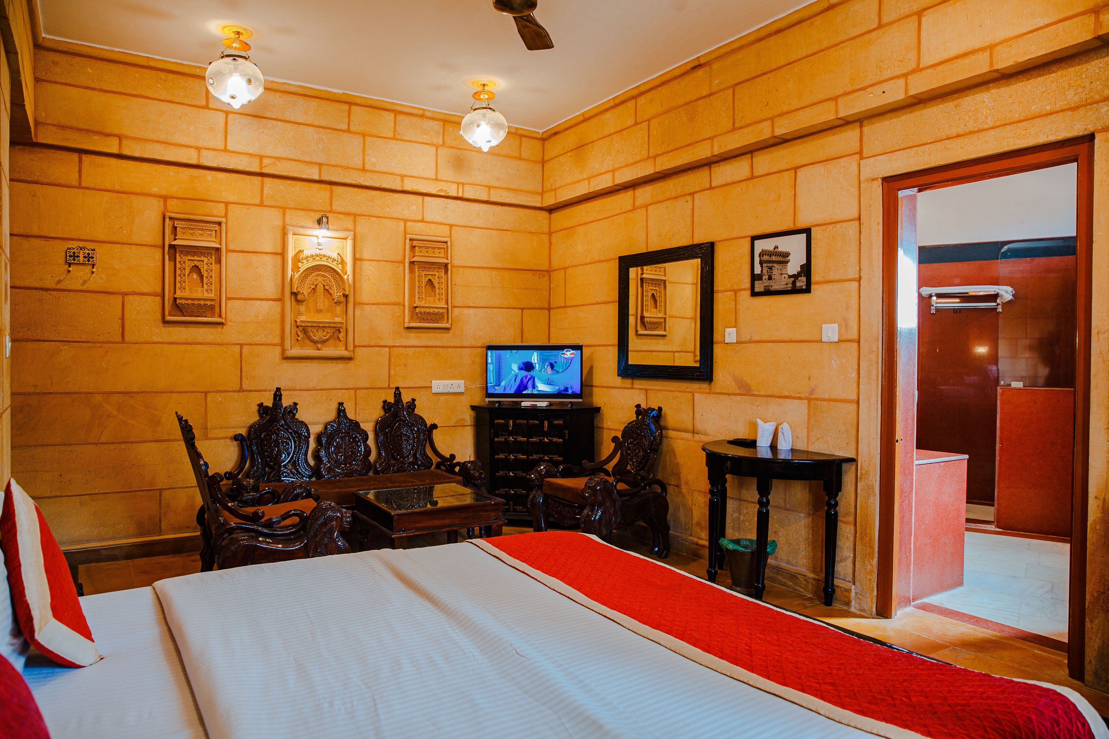 Ein Hotelzimmer mit einem großen Bett, Holzwänden, einem Fernseher und einem Holzkasten.