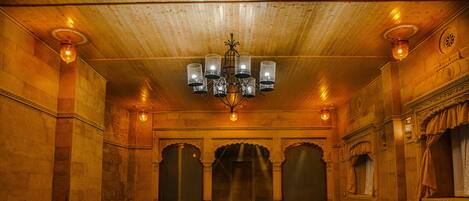 Una amplia piscina cubierta con techo de madera y columnas ornamentadas.