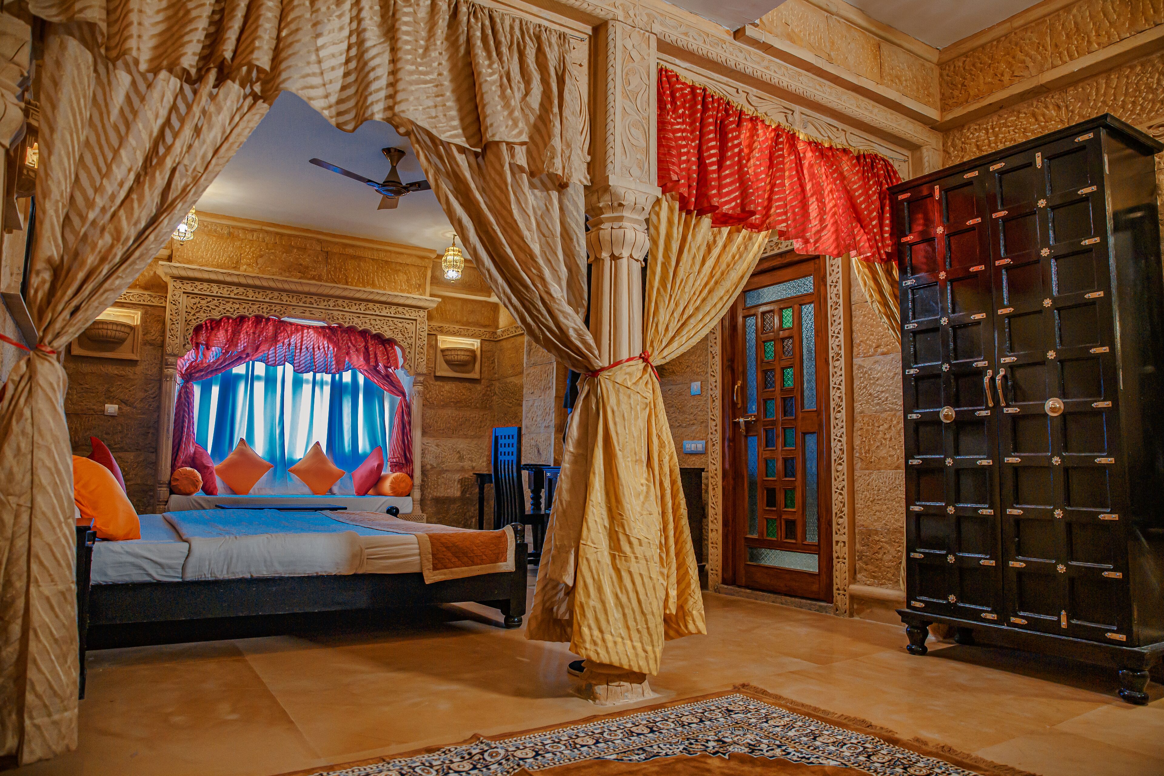 A bedroom with a bed, curtains, a wardrobe, and a rug.