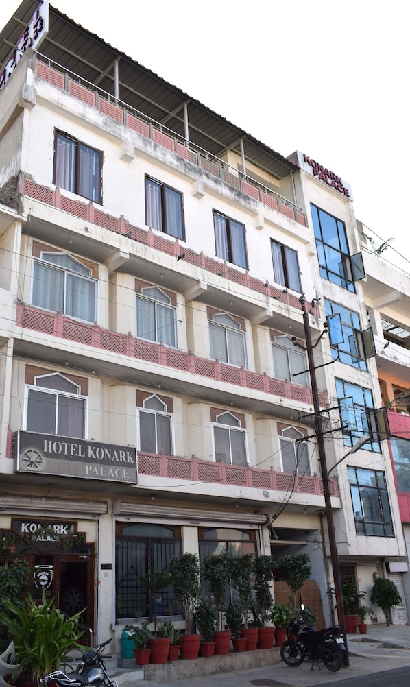 A multi-story hotel with balconies and a sign indicating it is the Konark Palace Hotel.