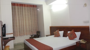 Una habitación de hotel con una cama, mesita de noche y teléfono.