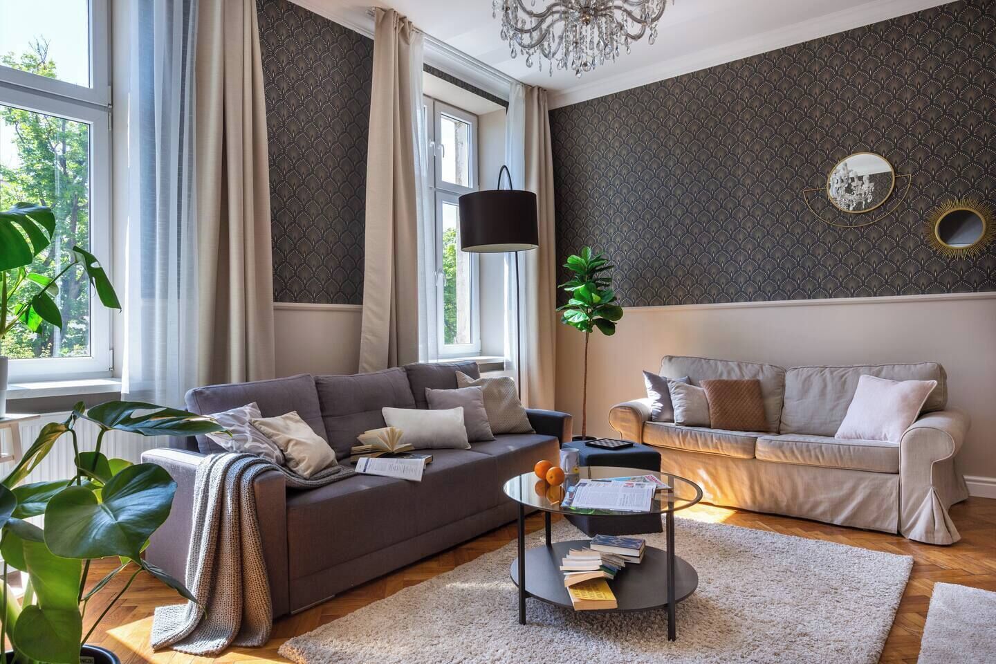 A living room with two sofas, a coffee table, a floor lamp, and a large window.