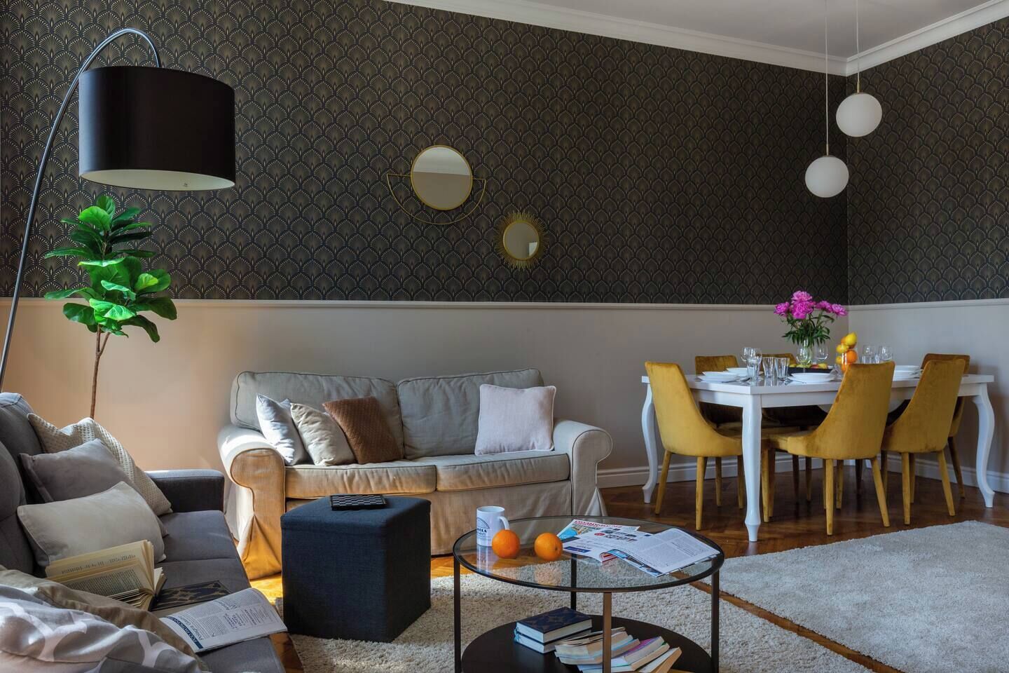 A modern living room with a sofa, coffee table, and dining area with chairs.