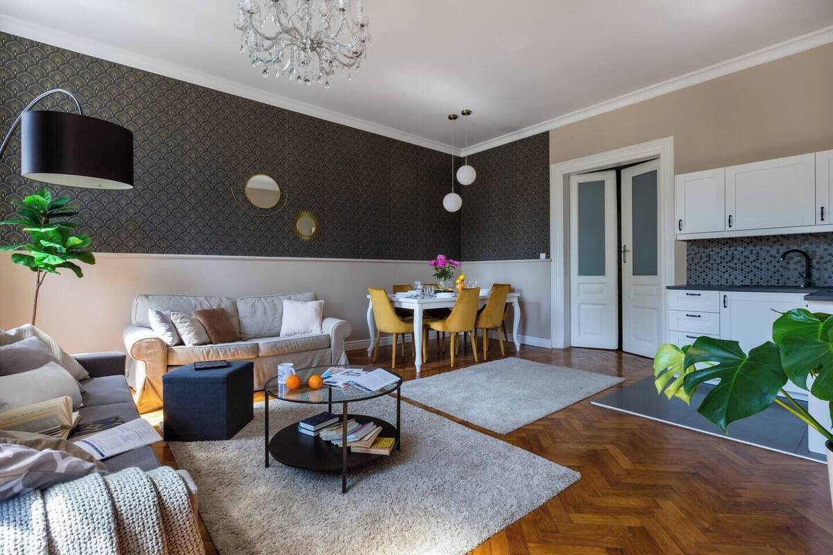 Una sala de estar moderna con sofá, mesa de centro, comedor y cocina.