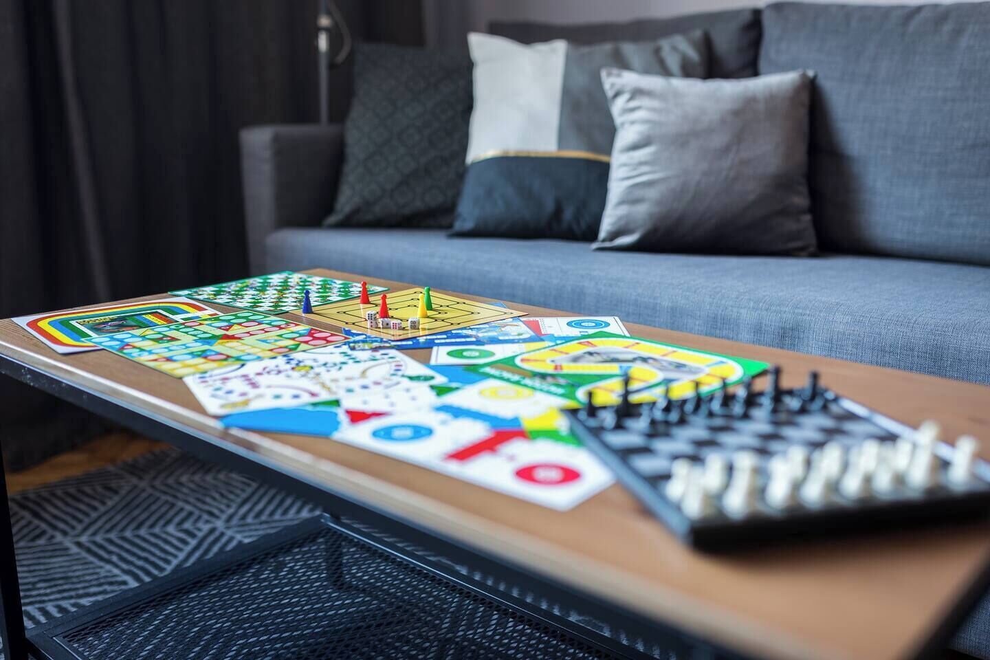 A board game on a table in a room with a sofa and pillows.