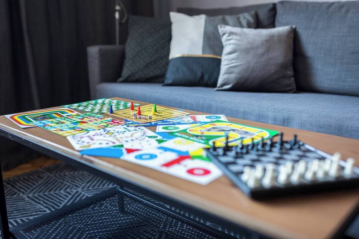 A board game on a table in a room with a sofa and pillows.