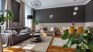 En moderne stue med sofa, sofabord, spisebord og stole.