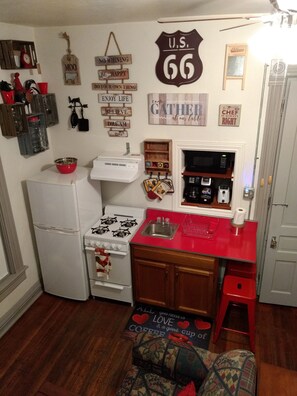 A compact kitchen with a refrigerator, stove, microwave, and a red countertop. - Beautiful Downtown Indy Guest Homes (Indianapolis)