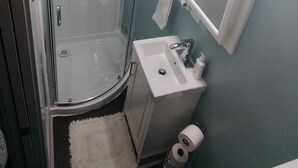 A bathroom with a glass-enclosed shower, a sink, and a toilet. - Beautiful Downtown Indy Guest Homes (Indianapolis)