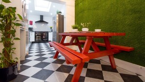 A modern kitchen with a black and white checkered floor, a red picnic table, and a green wall. - Modern Design House (Liverpool)