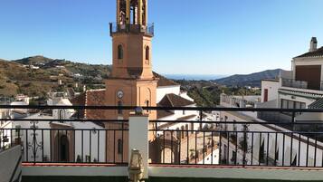 A terrace with a view of a historic tower and surrounding buildings.
